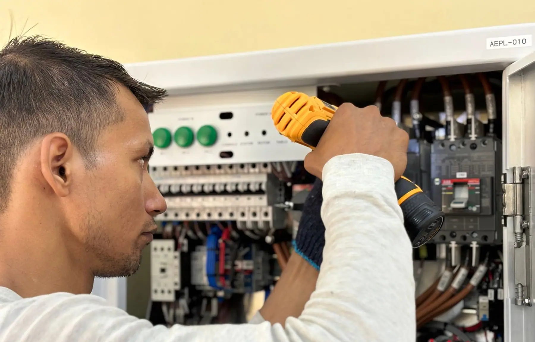 Elektriker misst in einem geöffneten Verteilerschrank
